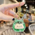 Cute green quicksand keychain with golden bell and metal ring, stylish bag pendant charm. - Glitter Green
