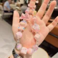 Cute cartoon doll beaded phone charm pendant and keychain accessory with pink iridescent beads. - Pink