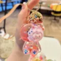 Detailed view of cute liquid glitter bear keychain with cartoon doll and sparkling sequins. - Pink