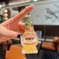 Cute liquid floating quicksand keychain with transparent shell, adorable cartoon doll charm for bags. - Liquid Orange