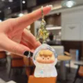 Cute liquid glitter keychain featuring an adorable cartoon doll pendant for stylish bag charms. - Beads-White