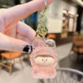 Acrylic quicksand keychain pendant with cute cartoon doll, glitter design and gold metal ring. - Pink