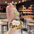 Close-up detail of cute quicksand keychain, featuring sparkling glitter and shiny gold ring. - Black