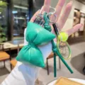 Green PU leather bow keychain with tennis racket charm, stylish designer bag accessory pendant. - Green