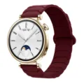 Detail view of a stylish gold smartwatch with a dark red magnetic silicone watch strap replacement. - 18mm / Burgundy