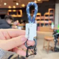Geflochtener Schlüsselanhänger mit weißem Lederetikett und robuster Hufeisen-Metallschnalle. - Blau