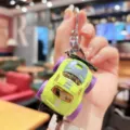 Detailed view of the mini alloy monster truck keychain with vibrant green body and purple wheels. - Green