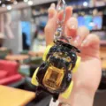 Mini alloy car model keychain with black body and yellow wheels, creative bag pendant detail. - Black