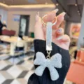Detailed shot of sparkling rhinestone bow keychain, luxury bag charm and elegant car key accessory. - Silver