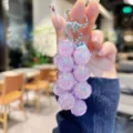 Detailed view of the purple acrylic grape cluster keychain, showing bead texture and metal clasp. - Transparent Pineapple String - Purple
