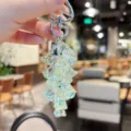 Detail shot of iridescent crystal lily of the valley keychain with silver metal hardware. - Translucent lily of the valley flower string—light green