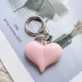 Detail view of cute candy pink heart alloy keychain pendant for bags and car keys accessories. - Light Pink