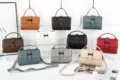 Detailed view of leather crossbody bags in multiple colors with metallic clasps and strap. - Teal