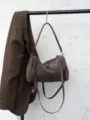 Brown suede shoulder bag detail showcasing minimalist design and premium texture. - Gray