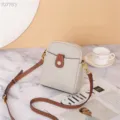 Detalle de bolso cruzado de cuero con bolsillo delantero y correa marrón ajustable. - Marfil