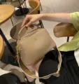 Λεπτομερής όψη πολυτελούς δερμάτινης τσάντας ώμου με φαρδύ λουρί και μεταλλικό ντεκόρ. - Γκρι ελέφαντα