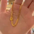 Nahaufnahme Detail des goldenen Curb-Chain-Armbands mit einem einzigartigen kleinen Anhänger. - S585 Schmale Breite 4mm (Länge 16cm)