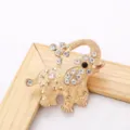 Detailed shot of gold-tone elephant rhinestone brooch, exquisite accessory for dress. - Gold