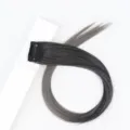 Detailed view of grey gradient clip-in hair extension piece with secure black clip for styling. - Black Ombre Granny Grey