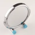 Close-up view of portable folding desktop makeup mirror with polished steel frame. - Silver