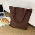 Nahaufnahme einer braunen Segeltuchtasche in einem gemütlichen Wohnambiente dekoriert. - Kaffeebraun