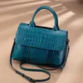 Detail view of vintage genuine leather women handbag, crocodile texture flap, stylish shoulder bag. - Blue