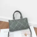 Detail shot of the gray-green stylish shoulder crossbody pillow bag with white contrast stitching. - 24*9*13cm / Green
