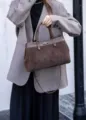 Elegante Veloursleder Henkeltasche in Kontrastfarbe mit Metall-Drehverschluss, Detail. - Kaffeebraun