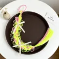 Vue détaillée de l'extension de cheveux tressés synthétiques colorés pour enfants avec nœuds perles. - Style 7