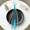 Accessorio per capelli da bambina con trecce colorate, fili di perline ed elastico per coda. - Stile 1