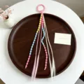 Extension per capelli colorate per bambini con perline e anello rosa, vista dettagliata. - Modello due