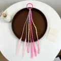 Vista di dettaglio delle trecce per capelli colorate da bambina con perline e anello. - Stile 4