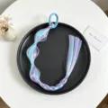 Vista dettagliata della treccia di capelli sintetica colorata posata su un piatto nero. - Stile 4