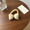 Vue détaillée d'un joli chouchou en tissu à pois jaunes posé sur une table en bois. - Jaune