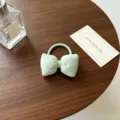 Gros plan détaillé d'un joli chouchou nœud vert clair à pois posé sur une table en bois. - Vert