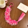 Primo piano di un'estensione di capelli intrecciati colorati per bambini con gradiente. - Anello per Capelli Sfumato Rosa e Bianco