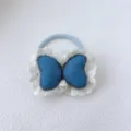 Gros plan détaillé d'un élastique à cheveux papillon en jean bleu avec une bordure en dentelle. - 1# Emballage Unique