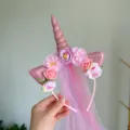 Detailed shot of a charming pink unicorn headband with flowers and gradient veil for girls. - Pink