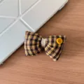 Nahaufnahme Detail der braunen karierten Stoff Schleife Haarklammer mit einem gelben Knopf. - 4# Gelb Kariert Haarklammer