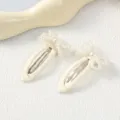 Primer plano detallado de lindo pasador de pelo con lazo de perlas diseño blanco diario. - Lazo / 1 Par / Blanco Roto