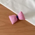 Gros plan d'un joli chouchou en tissu à carreaux roses, parfait pour coiffer vos cheveux. - Barrette Nœud Carreaux Rose