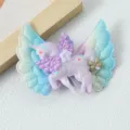 Detailed close-up of glittering unicorn hair clip with angel wings, sparkling sequins and bow. - Purple