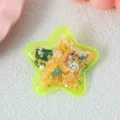Gros plan détaillé d'une jolie pince à cheveux étoile scintillante remplie d'étoiles et de fruits. - Barrette Jaune