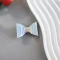 Gros plan détaillé d'une pince à cheveux nœud holographique étincelante avec finition pailletée. - Style de Barrette / Bleu