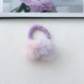 Primer plano detallado de una goma de pelo suave de pompones bicolores para niños con peluche. - Púrpura
