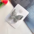 Gros plan détaillé de la pince à cheveux papillon double scintillante avec un design pailleté fin. - Pince à cheveux argentée