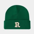 Gros plan d'un bonnet en maille vert foncé montrant la lettre R brodée sur le revers épais. - Verdoyant