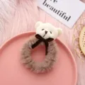 Close-up detail of a cute plush bear hair scrunchie with bow, soft furry texture design. - White Bowknot Bear + Coffee Hair Tie
