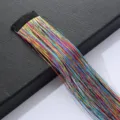 Detail of colorful laser tinsel hair extensions with black clip for shiny braids. - Multicolor