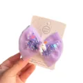 Closeup of cute purple mesh bow hair clip featuring unicorn and sparkling sequins for girls. - Purple